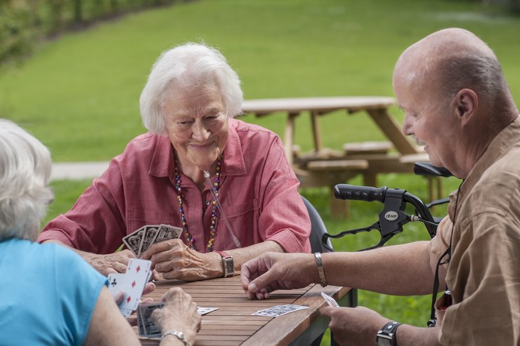 Bewohner im Pflegeheim beim Karten spielen